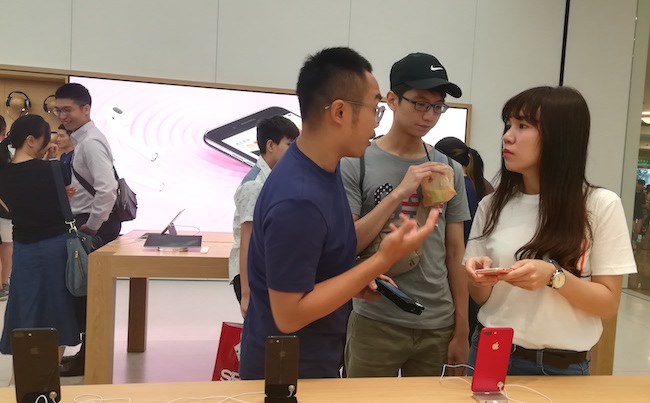 Nhân viên Apple Store đang giới thiệu sản phẩm với khách hàng.