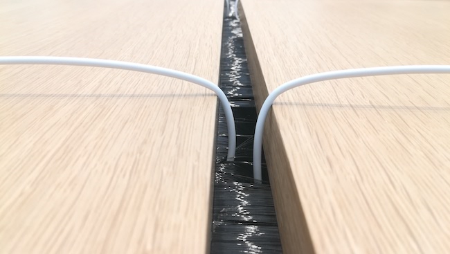Dây cáp nguồn được Apple kéo từ rãnh giữa bàn, phân bổ ra hai bên.