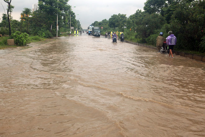 Đại lộ Thăng Long ngập sâu, dân xếp hàng thuê người chở xe - 1