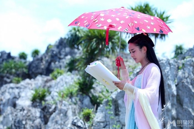 Triệu Lệ Dĩnh vừa đọc kịch bản vừa che ô (dù) khi quay phim “Hoa Thiên Cốt” giữa thời tiết khắc nghiệt.