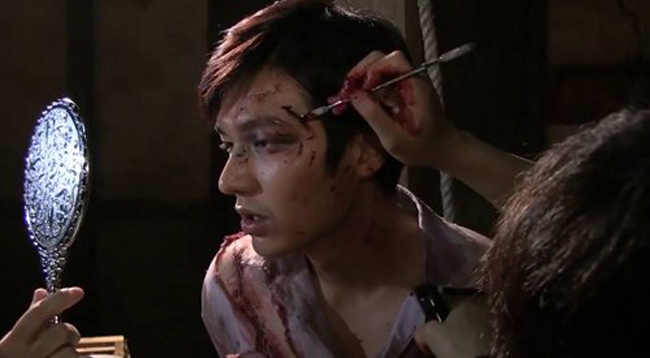 Tài tử Lee Min Ho cũng trông đáng sợ khi được hóa trang tạo vết bầm tím và thương tích đầy máu trên mặt.
