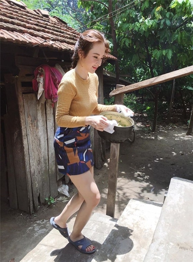 Angela Phương Trinh trong một chuyến thăm vùng quê cũng lăn vào bếp như một cô thôn nữ. Bỏ đôi giày cao gót hàng hiệu, "bà mẹ nhí" mang một đôi dép cao su cho tiện đi lại.