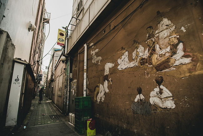 Một bức tranh về cảnh sinh hoạt truyền thống được vẽ lại trên tường con ngõ nhỏ.