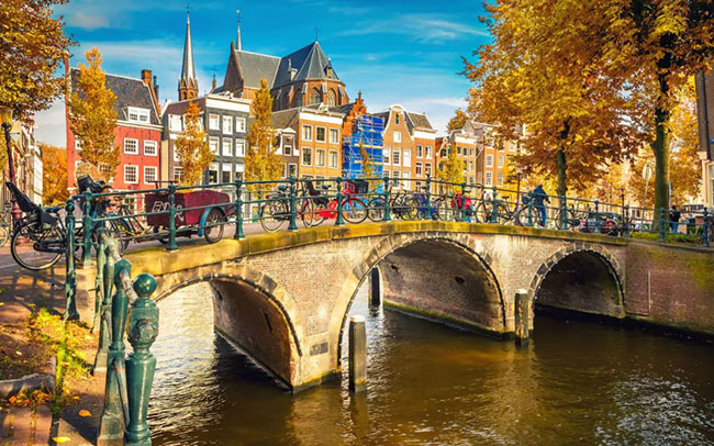 Amsterdam

Hãy quên những cánh đồng hoa mùa xuân và những bài hát về hoa tulip: mùa thu chính là thời gian vàng để ghé thăm Amsterdam. Thành phố trở nên tuyệt vời nhất khi mùa hè nhẹ nhàng biến mất, khi lá cây dọc theo các con kênh rạch đã chuyển sang màu vàng  và trong ánh nắng chiều thu nhàn nhạt cả thành phố như được nhuộm trong màu vàng kim long lanh rực rỡ. Lúc này không gì tuyệt hơn được ngồi trong quán cà phê ven đường nhìn ngắm phong cảnh nên thơ, hoặc ghé thăm các cuộc triển lãm tại Bảo tàng Van Gogh. Mùa thu ở Amsterdam thậm chí còn hấp dẫn hơn cả mùa xuân.