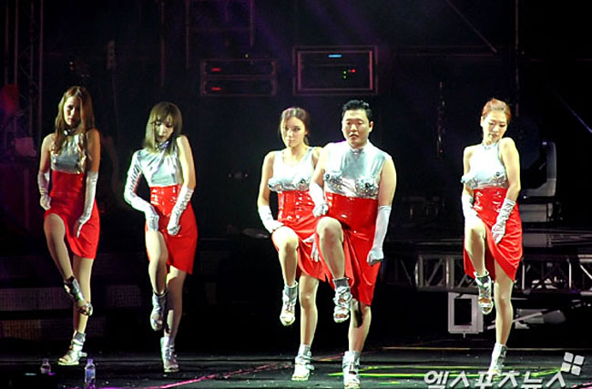 Đặc biệt trang phục của Psy trên sân khấu phần lớn là những “bộ cánh” bắt chước trang phục nữ giới, kiểu jumpsuit hay kiểu áo ngực nhọn hoắt.