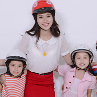 Thu Thảo dạy trẻ nhỏ đội mũ bảo hiểm
