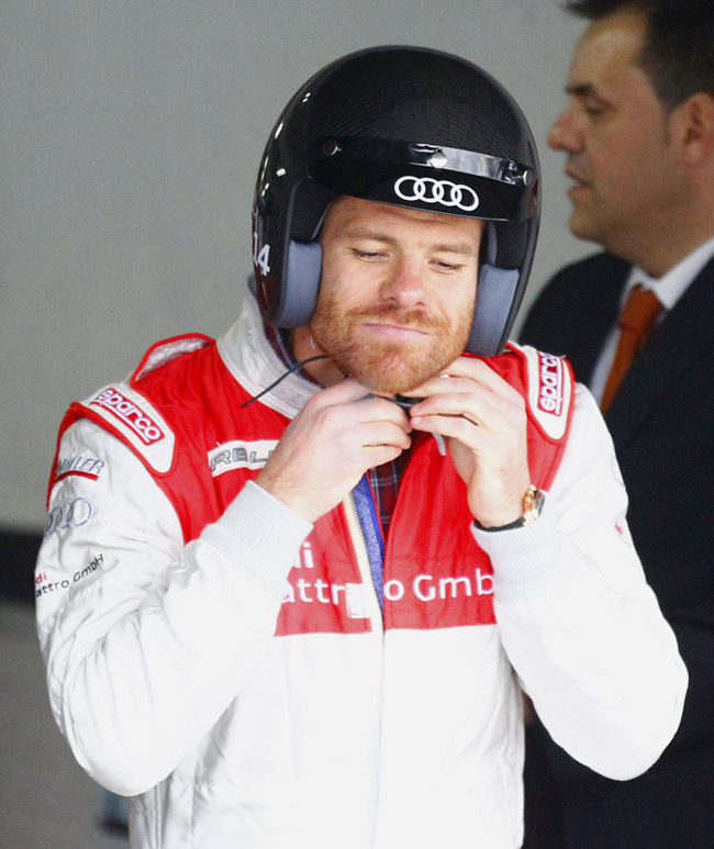 Xabi Alonso đang thắt chặt mũ bảo hiểm để trải nghiệm trên chiếc xe đua mới của Audi