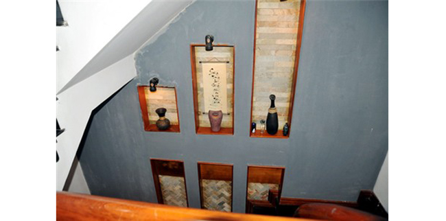 Mỗi góc cầu thang lên xuống đều trang trí bằng những vật dụng đồ cổ và bức tranh thêu
