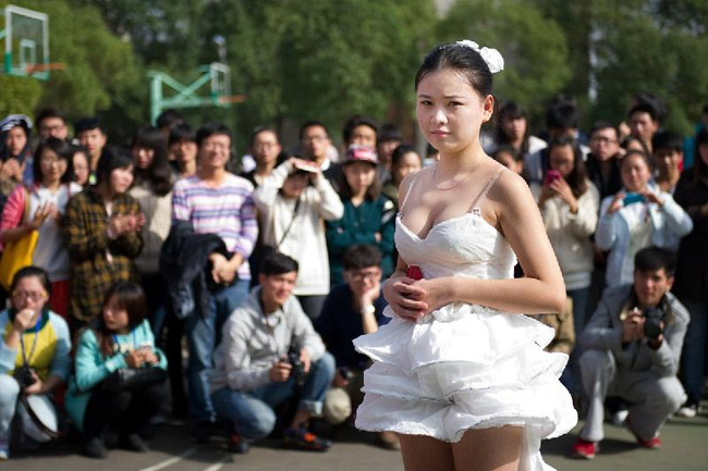 Họ mặc những chiếc váy cưới làm bằng giấy, đi xuống dọc theo các con đường lớn của trường.
