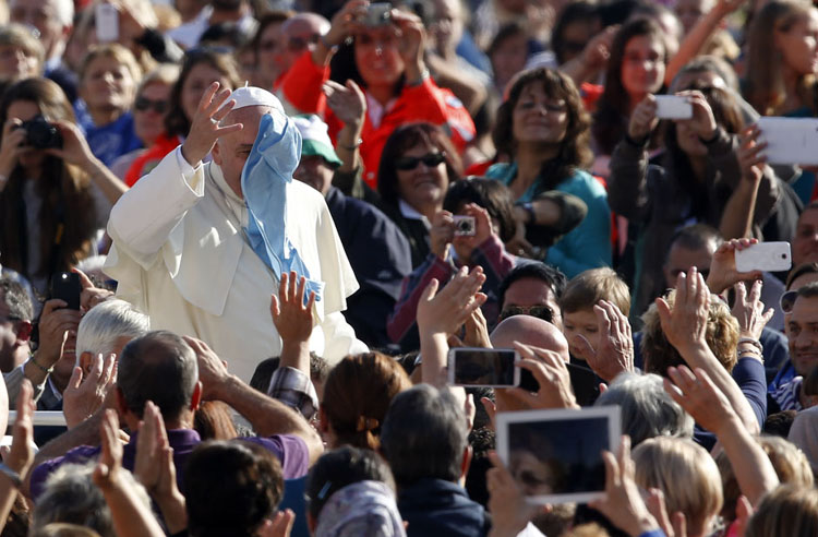Giáo hoàng Francis vẫy tay trước đám đông, và một người tìm cách ném cho ông chiếc khăn tay để tỏ lòng yêu mến tại quảng trường Thánh Peter ở Vatican hôm 16/10/2013.
