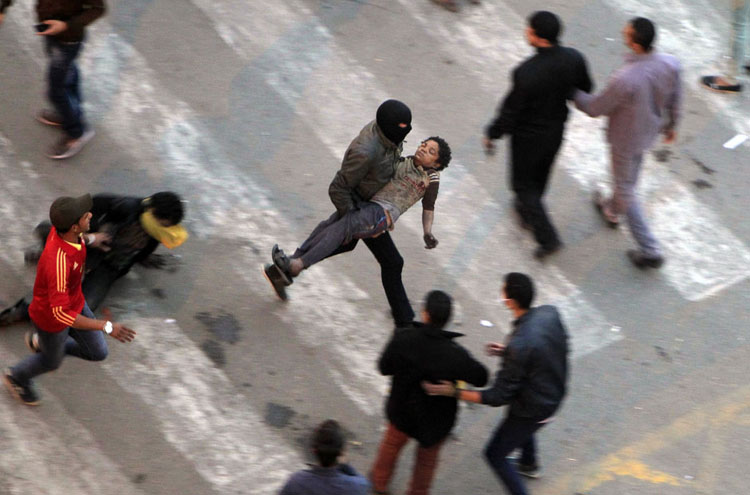 Người biểu tình bỏ chạy tán loạn sau khi cảnh sát chống bạo động bắn hơi cay trong những vụ đụng độ với người biểu tình ở đường Qasr al-Aini gần quảng trường Tahrir ở thủ đô Cairo, Ai Cập hôm 24/1/2013.
