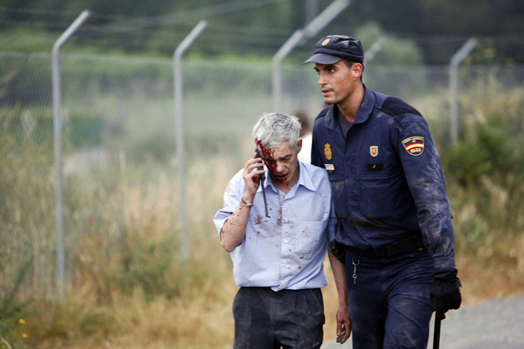 Lái tàu Francisco Jose Garzon được một cảnh sát giúp đỡ sau khi bị thương vì con tàu trật bánh và đâm vào một bức tường bê tông ở Santiago de Compostela, Tây Ban Nha hôm 24/7/2013.
