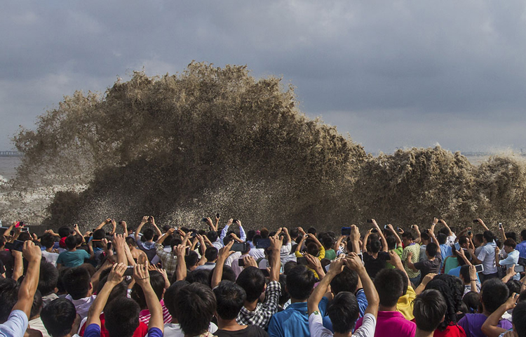 Người dân đua nhau chụp ảnh những con sóng khổng lồ ập vào bờ dưới ảnh hưởng của siêu bão Usagi ở Hàng Châu, Chiết Giang, Trung Quốc ngày 22/9/2013.
