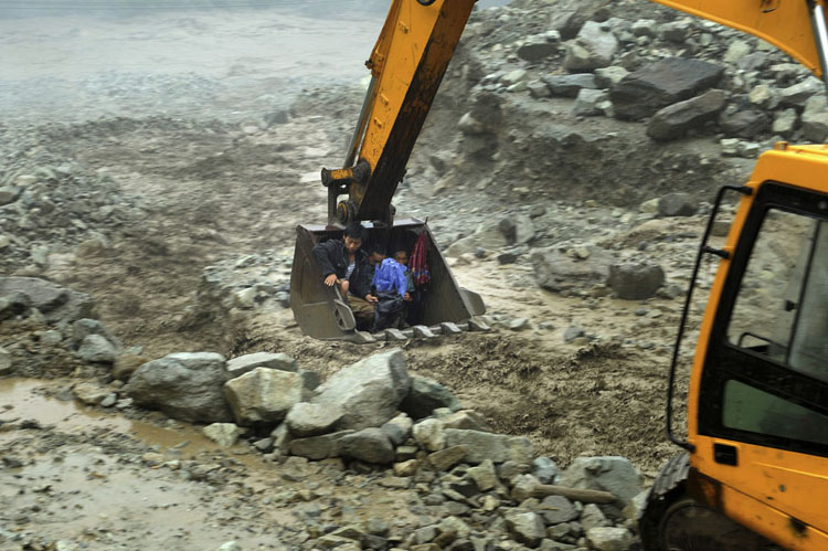 Một chiếc máy xúc di tản dân làng khỏi khu vực lũ lụt trong trận mưa lớn lịch sử ở tỉnh Tứ Xuyên, Trung Quốc hôm 10/11/2013.
