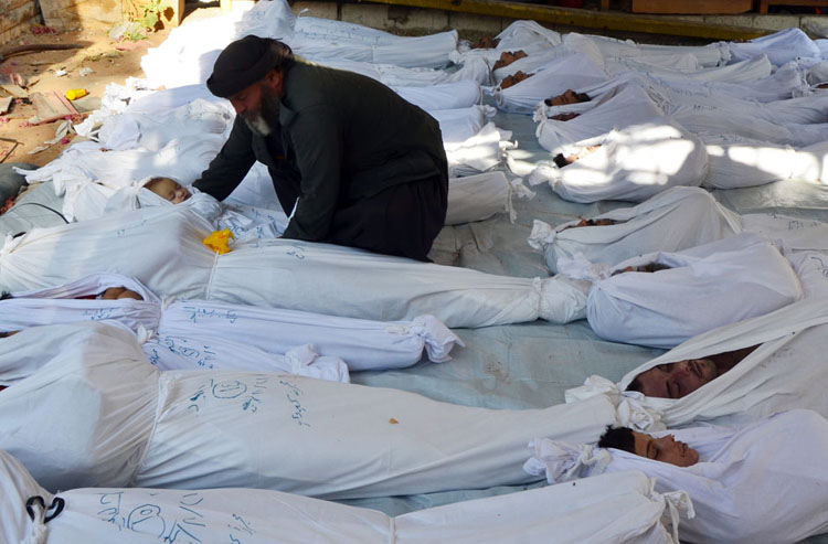 Một người đàn ông ôm thi thể của một cháu bé được cho là bị sát hại bởi khí độc thần kinh ở Ghouta, ngoại ô thủ đô Damascus của Syria hôm 21/8/2013.
