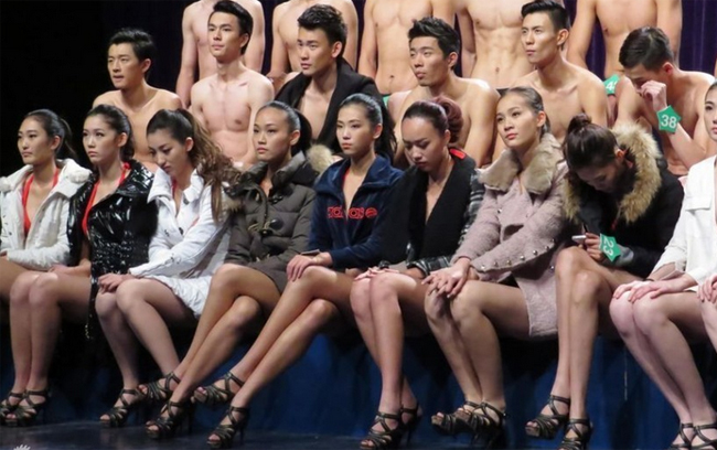 Dàn người mẫu ngồi đợi đến lượt diễn. Các cô gái khoác áo dày sụ giữ ấm cơ thể
