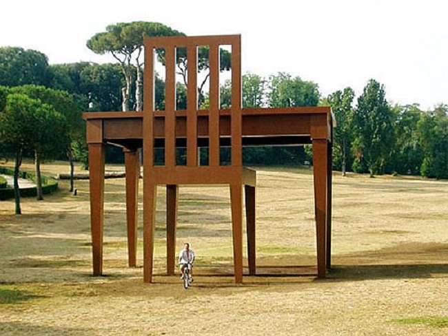 Bức ảnh chụp lại tác phẩm điêu khắc “Nhà văn” của tác giả Giancarlo Neri. Tác phẩm là một bàn ghế cao 9m được làm từ gỗ và thép và được trưng bày tại Rome (Ý) và Hampstead Health (Luân Đôn, Anh) năm 2005.


