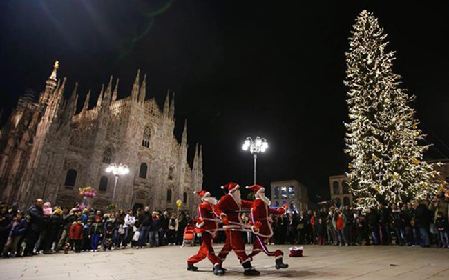 Những nghệ sĩ mặc trang phục Ông già Noel biểu diễn trước thánh đường Duomo ở thành phố Milan, Italy.
