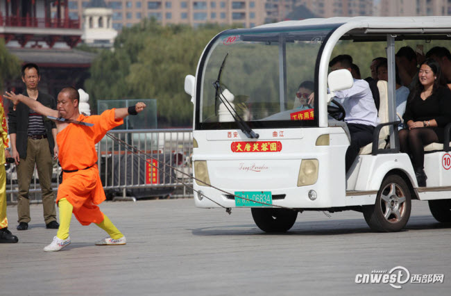 Hu Qiong, được mệnh danh là “La Hán sắt”, kéo một chiếc xe điện chở 12 người với chiếc dao sắc ở cổ.