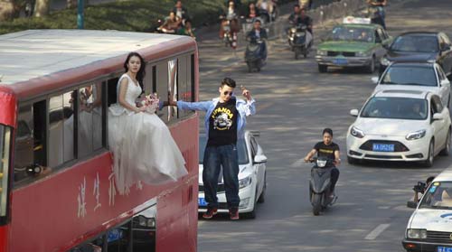 Cô gái mặc váy cưới treo mình lơ lửng trên xe buýt - 1