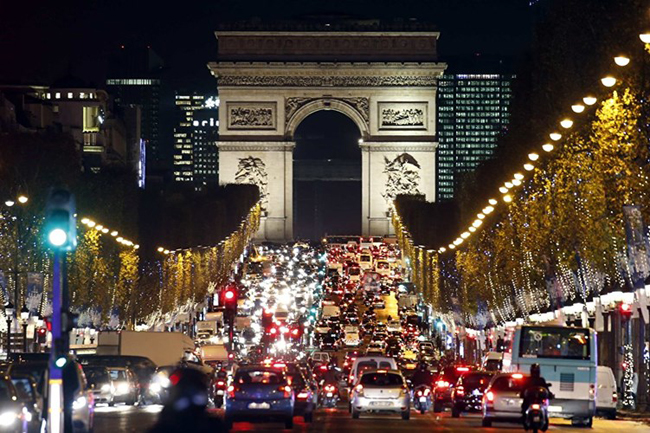 Hàng trăm bóng đèn điện treo trên hàng cây chạy dọc đại lộ Champs Elysees tới đường Arc de Triomphe ở Paris.
