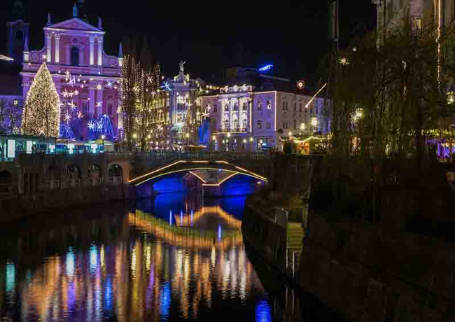 Đèn nhấp nháy làm những tòa nhà ven sông Ljubljanica ở Ljubljana, Slovenia sáng rực trong đêm. Cuối tháng 11, đầu tháng 12, người dân đã bắt tay trang hoàng nhà cửa để mang không khí giáng sinh về khắp mọi nơi.
