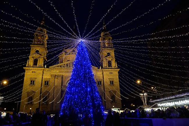 Một cây thông Noel được thắp sáng rực rỡ trước nhà thờ Thánh Stephen ở Budapest (Hungary).
