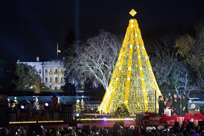 Gia đình tổng thống Mỹ Barack Obama cùng nữ diễn viên Reese Witherspoon cùng nhau ấn nút thắp sáng cây thông Noel ở thủ đô Washington (Mỹ).