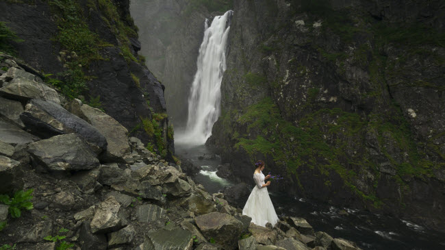 Bức ảnh chụp cô dâu mới cưới Nienartowicz đứng trước thác nước đẹp như tranh vẽ.