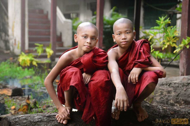 Hai chú tiểu ngồi cạnh nhau trên khúc gỗ trong một tu viện ở thành phố Bago.