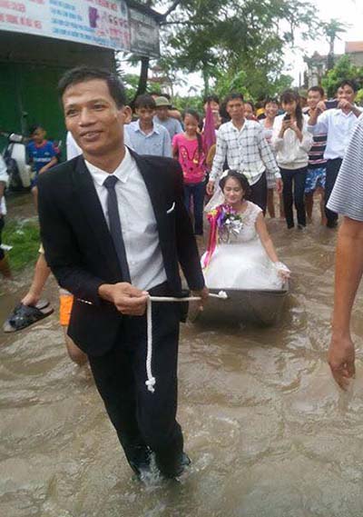 Video cô dâu ngồi thuyền hoa khi đường ngập lụt gây sốt mạng - 1