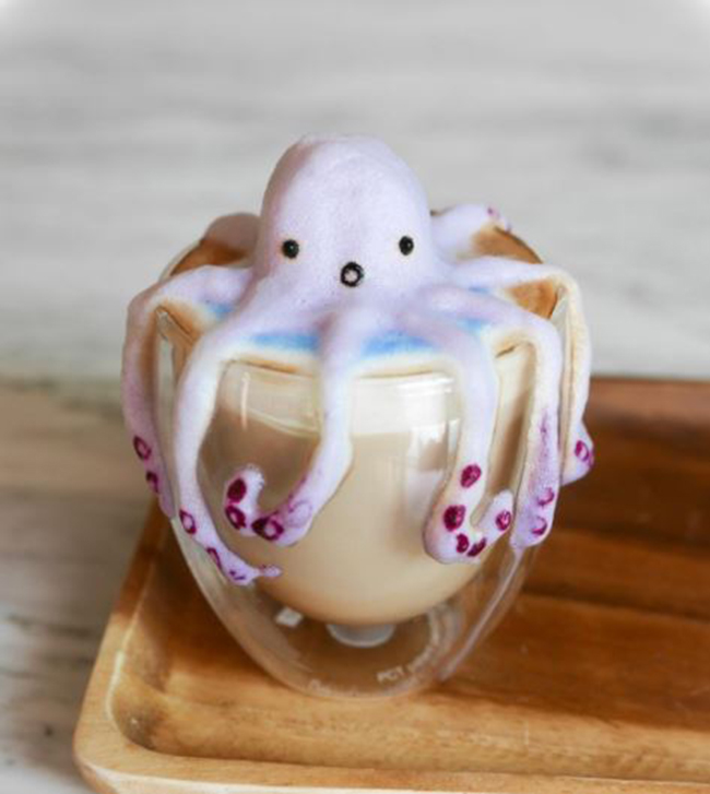 Một con bạch tuộc tí hon đang vươn những xúc tu của mình ra khỏi ly.