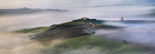 Sương sớm bao phủ những ngọn đồi xanh mướt ở Tuscany, Italia. Ảnh: Pavel Oskin