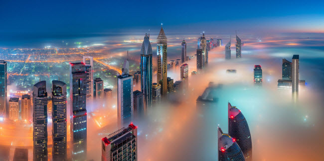 Sương mù bao phủ các tòa nhà cao tầng tỏa sáng lung linh trong đêm ở Dubai. Ảnh: Sebastian Tontsch