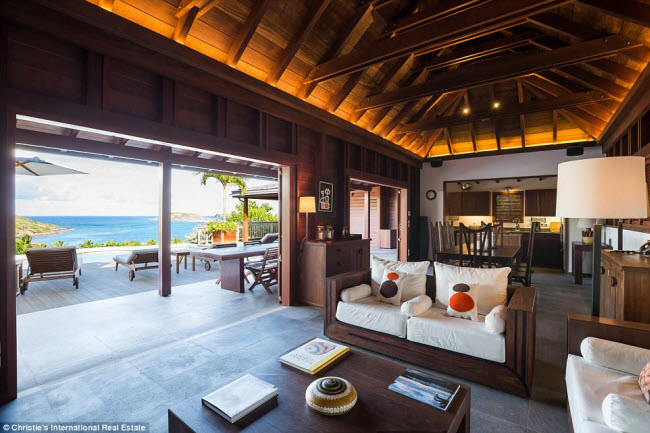 Phòng khách bao gồm đồ nội thất bằng gỗ và không gian mở nhìn ra biển.
