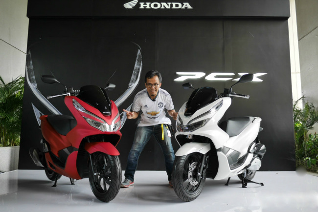 2018 Honda PCX 150 mới được PT Astra Honda Motor (AHM) tung ra thị trường Indonesia với 2 phiên bản ABS (chống bó cứng phanh) và CBS (phanh liên hợp), cùng bốn màu tùy chọn gồm màu trắng, đen, vàng và màu đỏ. Ảnh 2018 Honda PCX 150 bản màu đỏ và màu trắng.