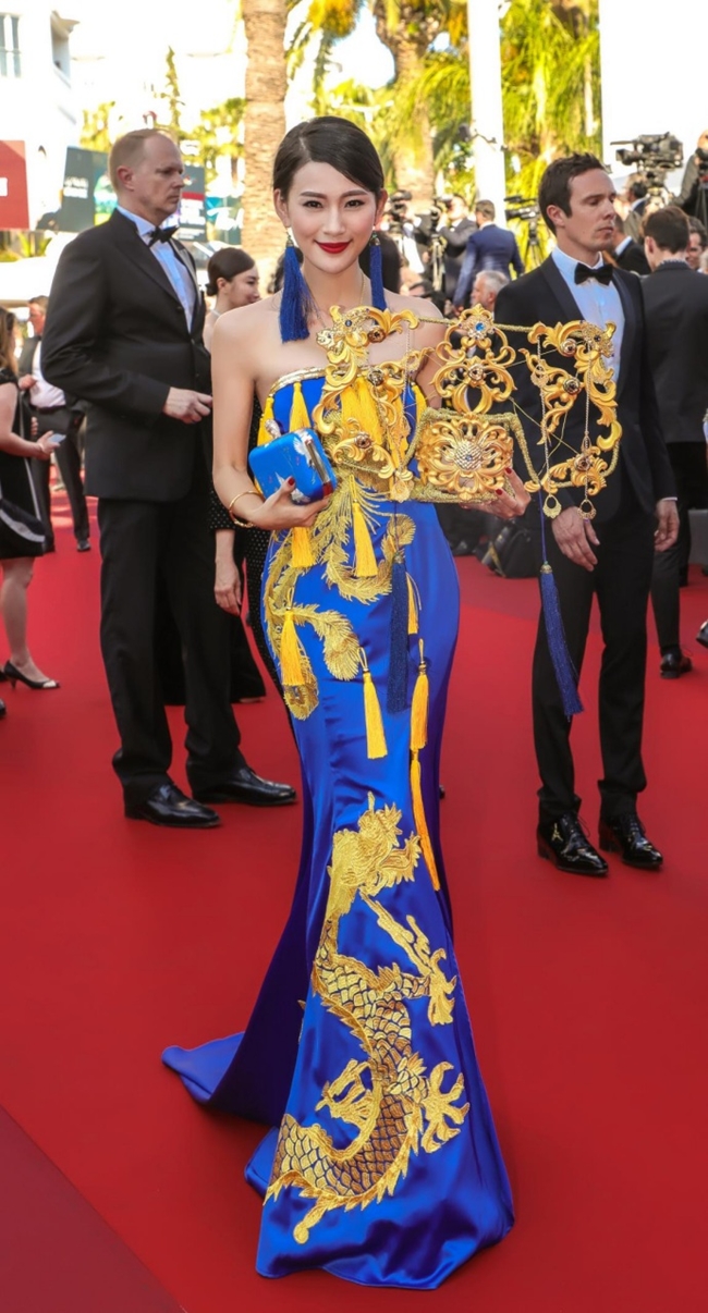 Đến ngày cuối cùng của LHP Cannes 2017, một người đẹp vô danh khác quyết "chơi trội" bằng cách diện váy long bào cùng chiếc mũ mạ vàng cầu kỳ.